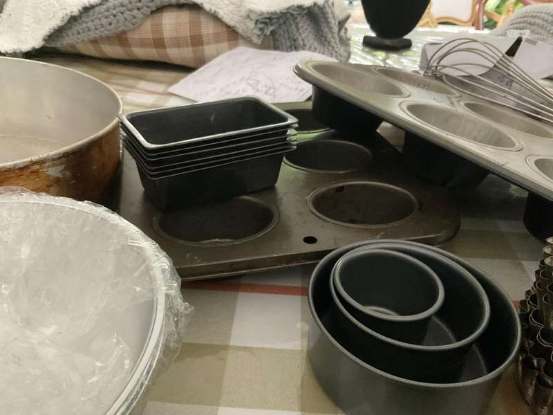 A selection of muffin baking trays, tart tins ,small cake tins and a large whisk.