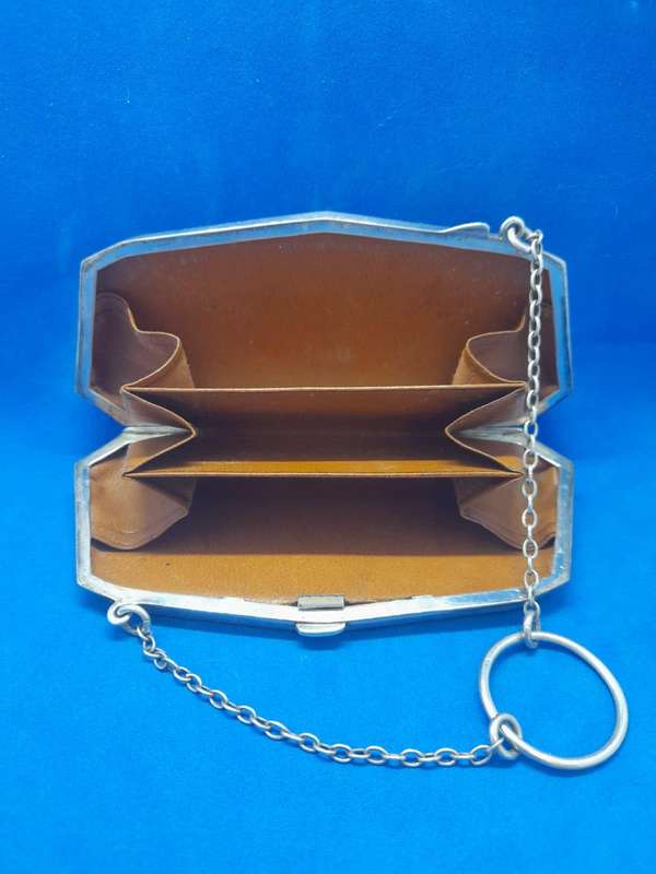 Silver coin purse with calf leather interior.