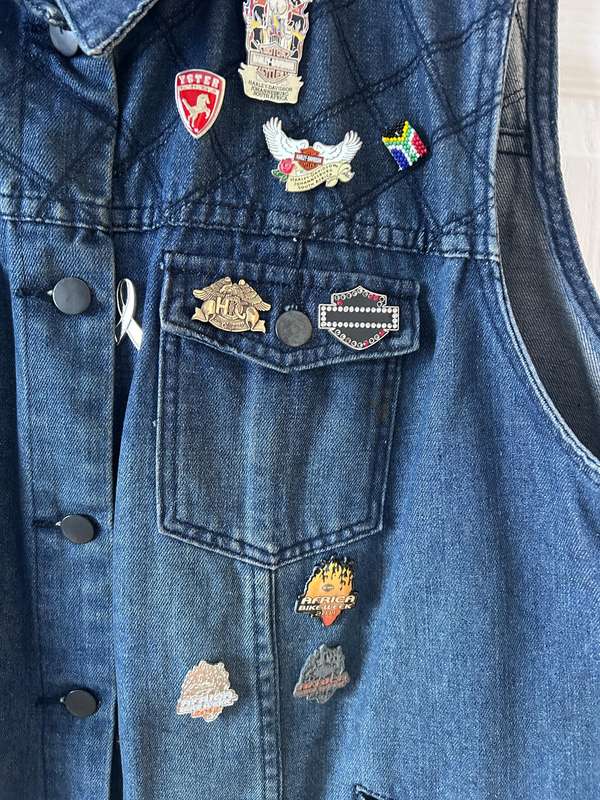 RENE TAYLOR denim motorcycle vest covered with a variety of pins and patches