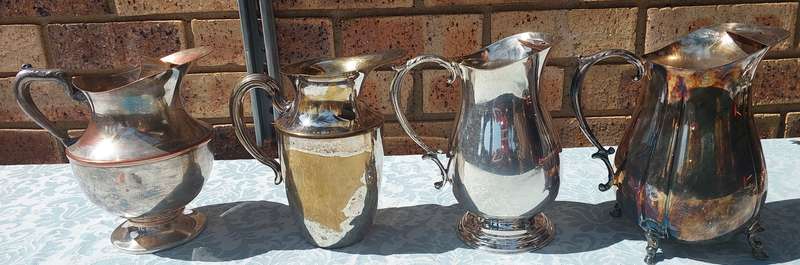 AN ANTIQUE COLLECTION SILVER PLATED WATER JUGS