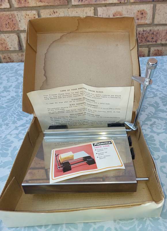 A VINTAGE PINE WARE CHEESE SLICER IN IT ORIGINAL PACKAGING