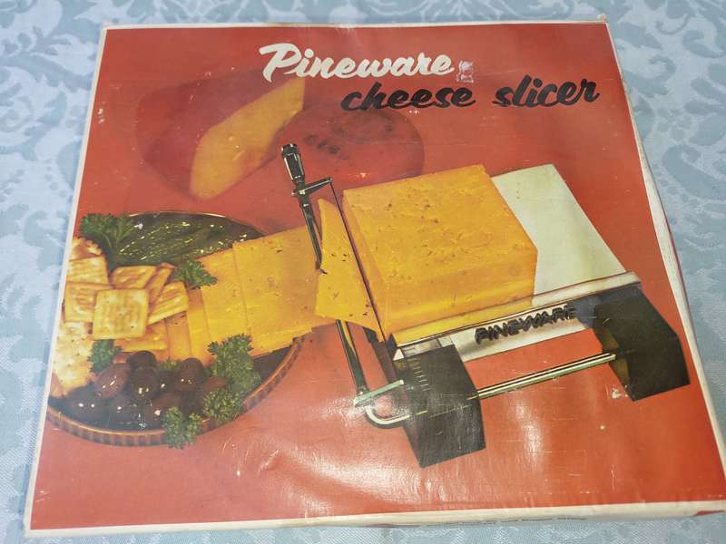 A VINTAGE PINE WARE CHEESE SLICER IN IT ORIGINAL PACKAGING