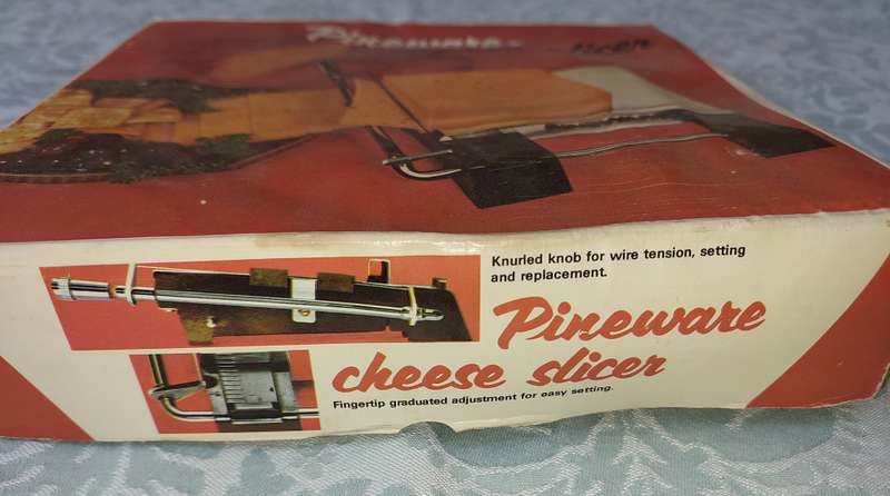 A VINTAGE PINE WARE CHEESE SLICER IN IT ORIGINAL PACKAGING
