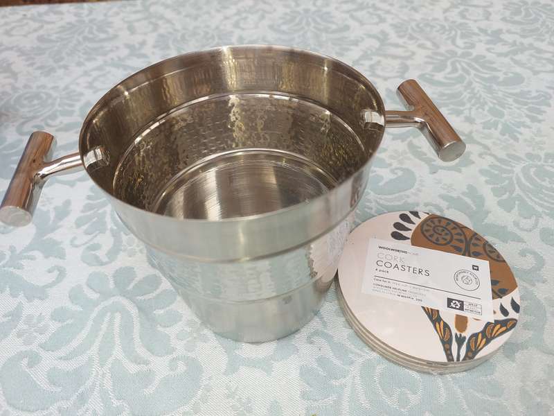 A STAINLESS STEEL ICE BUCKET AND A SET OF 4 COASTERS
