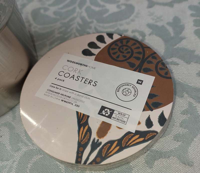 A STAINLESS STEEL ICE BUCKET AND A SET OF 4 COASTERS