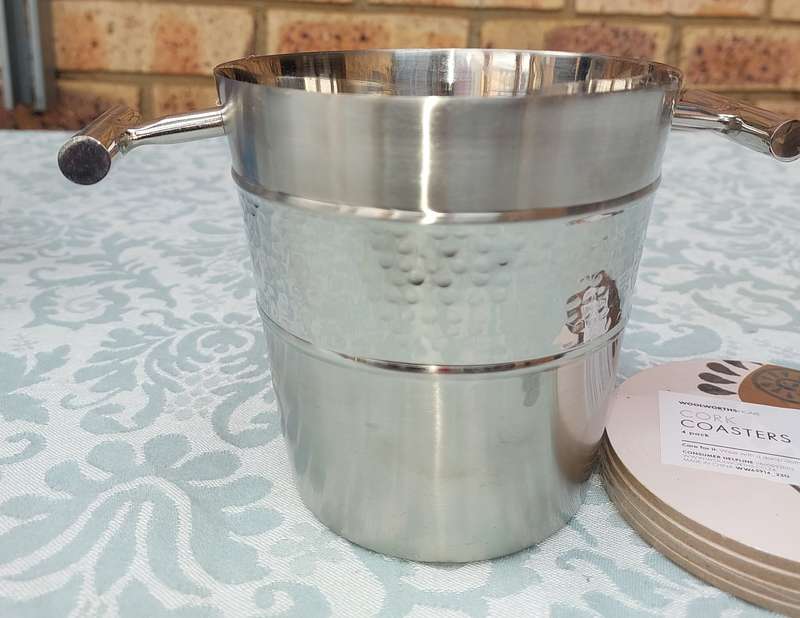 A STAINLESS STEEL ICE BUCKET AND A SET OF 4 COASTERS