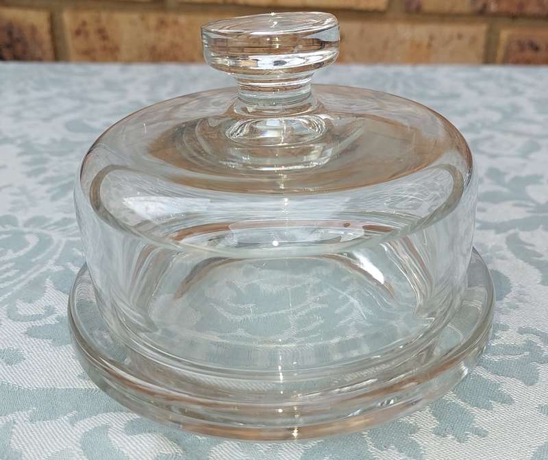 A SOLID GLASS BUTTER BOWL WITH A LID