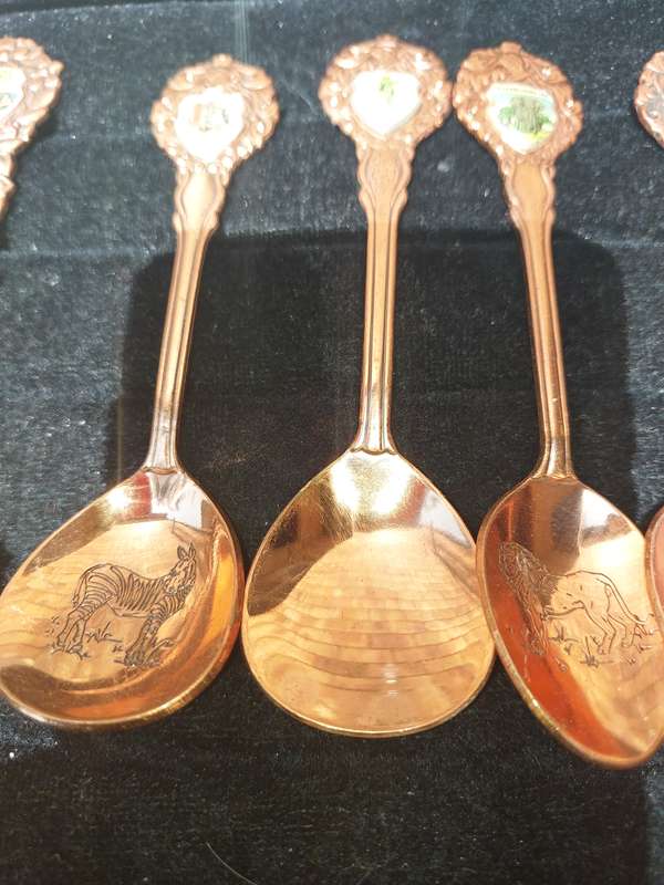 A COLLECTION OF 11 COPPER AFRICAN GAME ANIMAL MEMORABILIA SPOONS