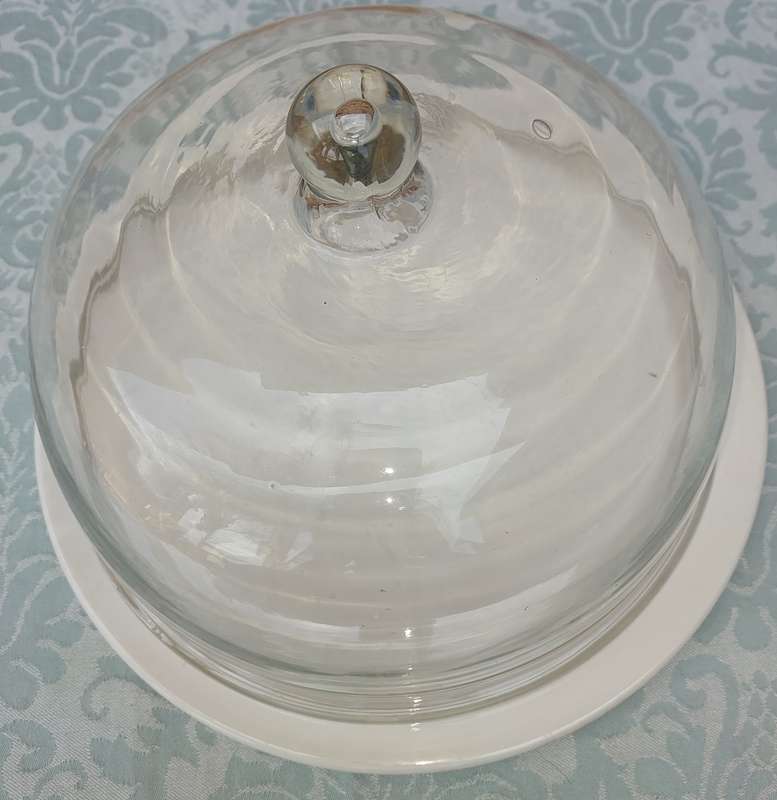 A WHITE PORCELAIN CAKE PLATE WITH A HEAVY GLASS DOME