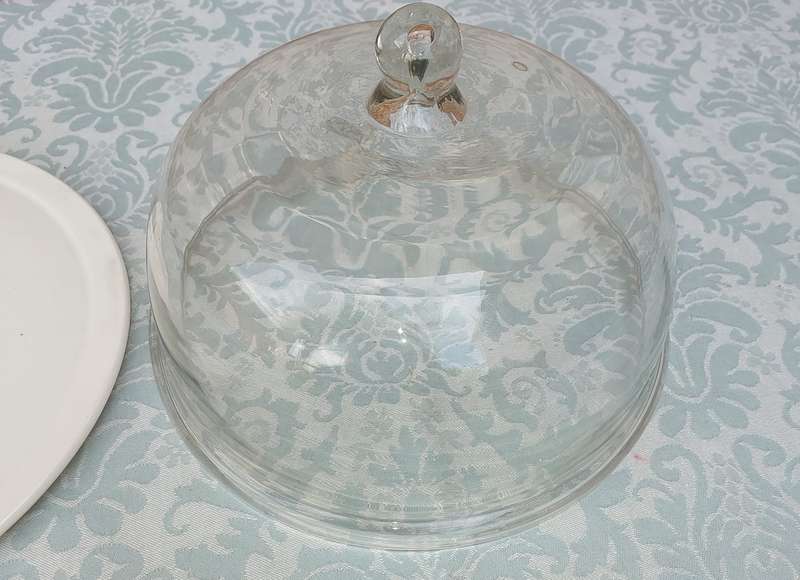 A WHITE PORCELAIN CAKE PLATE WITH A HEAVY GLASS DOME