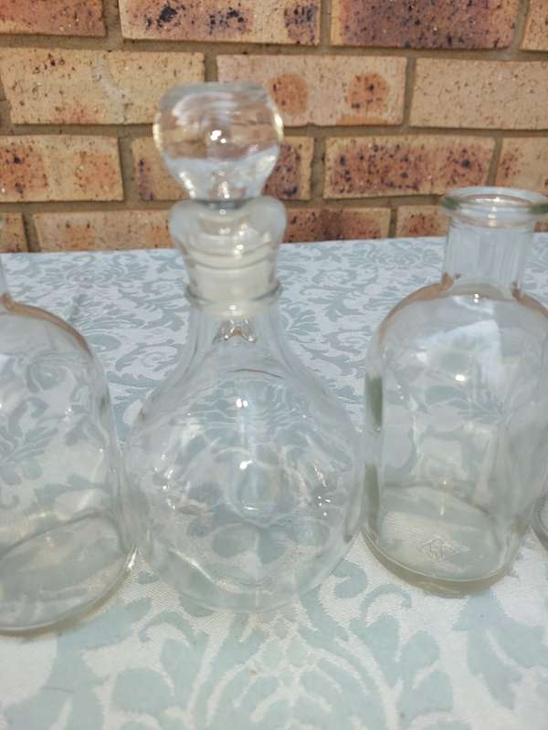 A COLLECTION OF GLASS SAUCE BOTTLES SOLD AS IS