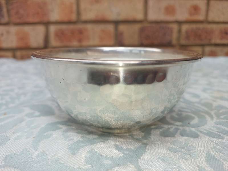 A STAINLESS STEEL BOWL CANDLE HOLDER