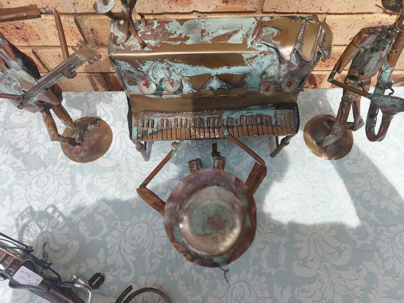 A COLLECTION OF COPPER FIGURINE ART SCULPTURES A PIANIST ,A PIANO WITH A SAXOPHONIST AND A BICYCLE