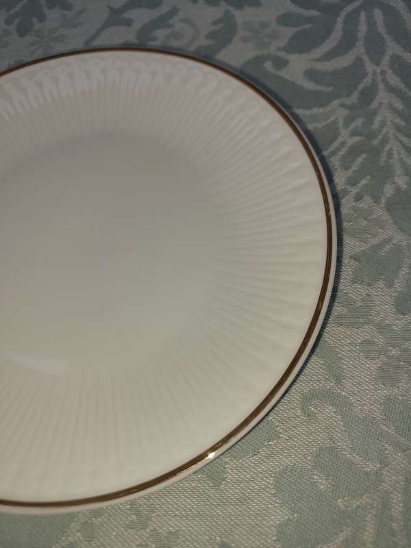A VINTAGE SET OF 12 WHITE PORCELAIN AND GOLD TRIM SIDE PLATES