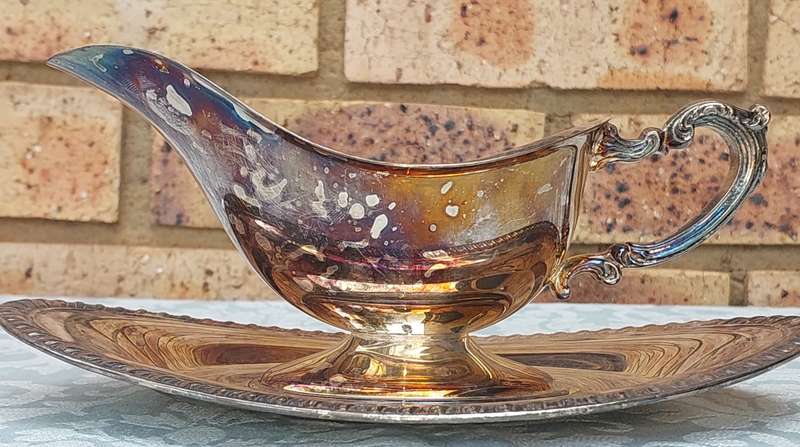A SIVERPLATED SAUCE JUG EDWARDIAN STYLE WITH A TRAY SOLD AS IS