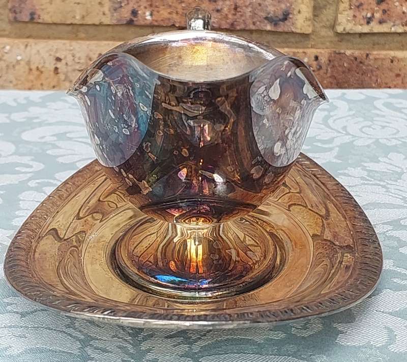 A SIVERPLATED SAUCE JUG EDWARDIAN STYLE WITH A TRAY SOLD AS IS