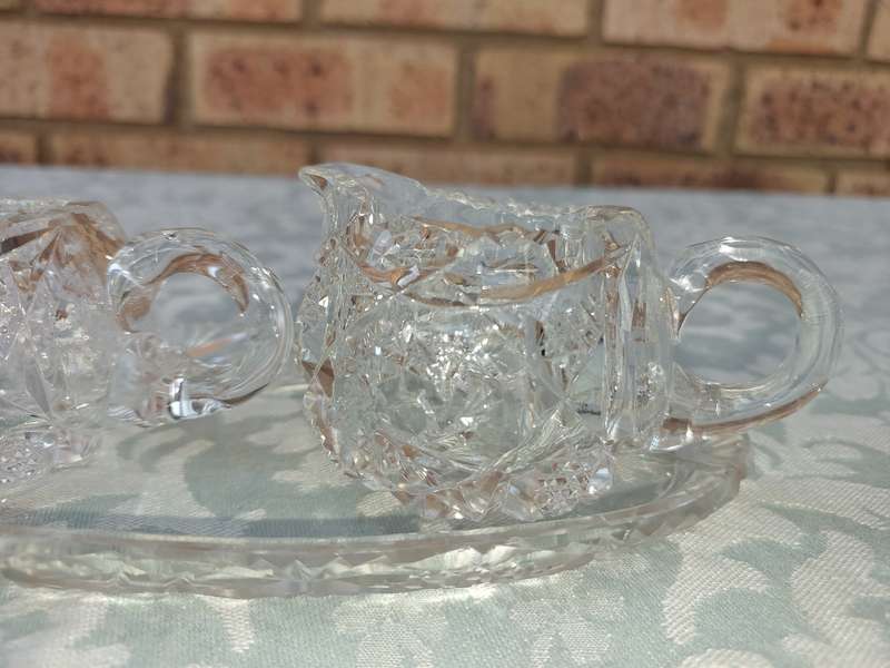 AN ART DECOR GLASS SUGAR BOWL AND A MILK JUG SOLD AS IS