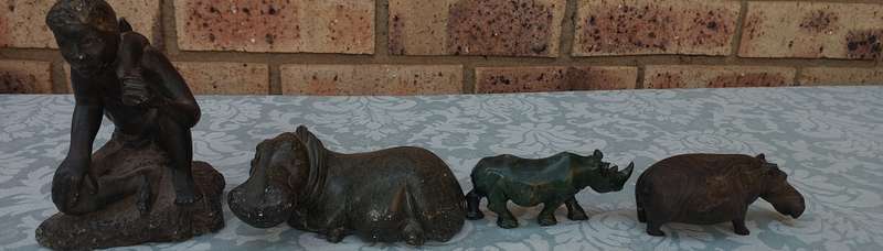 A COLLECTION OF AFRICAN HUNTER AND ANIMAL SCULPTURES SOLD AS IS