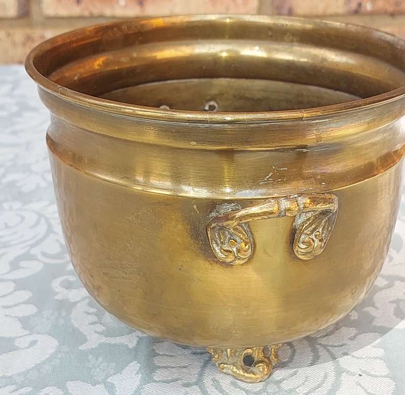 A VINTAGE BRASS FOOTED POTPLANT HOLDER SOLD AS IS R200
