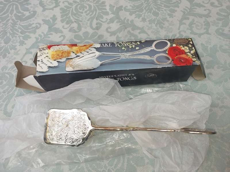 A CAKE TONG NEVER USED SILVER PLATED SOLD AS IS