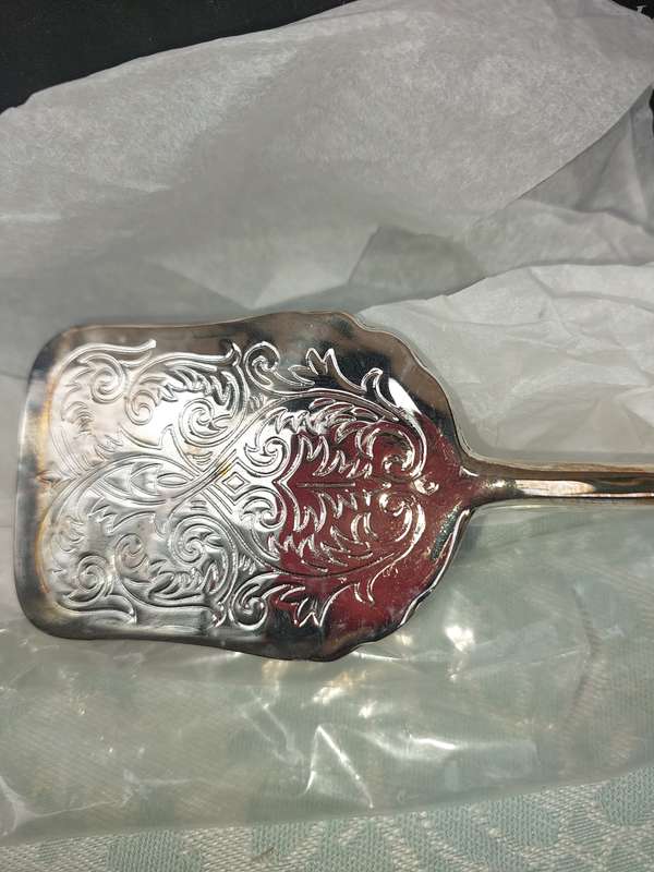 A CAKE TONG NEVER USED SILVER PLATED SOLD AS IS