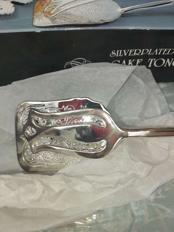 A CAKE TONG NEVER USED SILVER PLATED SOLD AS IS