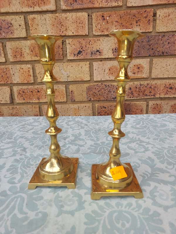 A PAIR OF BRASS CANDLE HOLDERS SOLD AS IS