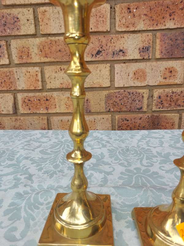 A PAIR OF BRASS CANDLE HOLDERS SOLD AS IS
