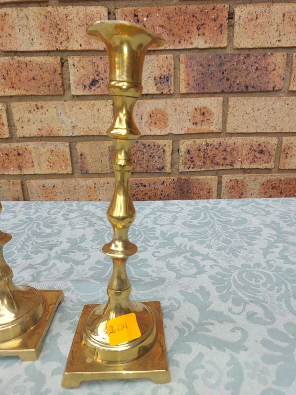 A PAIR OF BRASS CANDLE HOLDERS SOLD AS IS