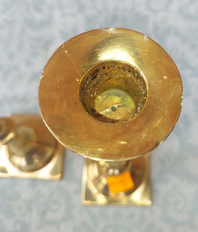 A PAIR OF BRASS CANDLE HOLDERS SOLD AS IS