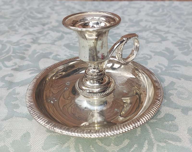 A SILVERPLATED CANDLE HOLDER SOLD AS IS