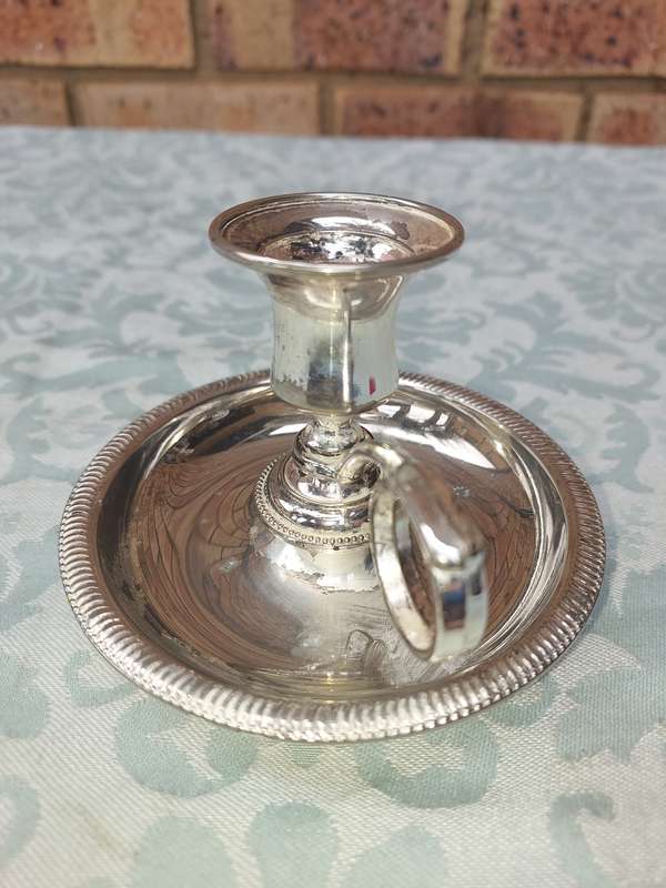 A SILVERPLATED CANDLE HOLDER SOLD AS IS