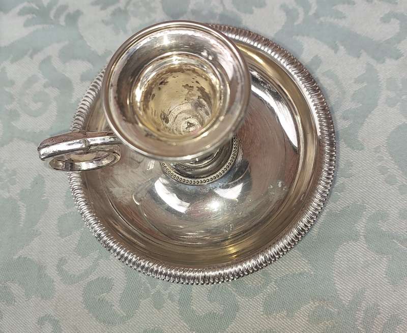 A SILVERPLATED CANDLE HOLDER SOLD AS IS