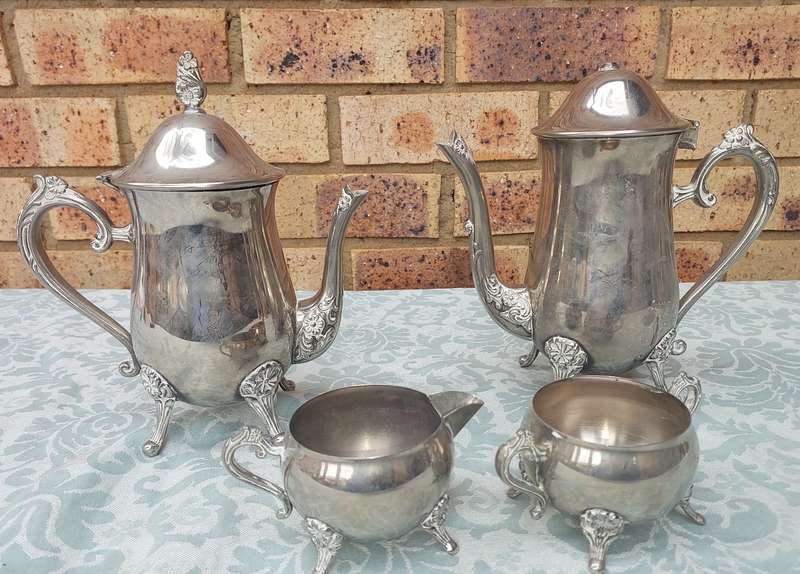 A VINTAGE SILVERPLATE TEAPOT SET WITH A LID HANDLE MISSING SOLD AS IS
