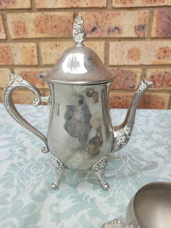 A VINTAGE SILVERPLATE TEAPOT SET WITH A LID HANDLE MISSING SOLD AS IS