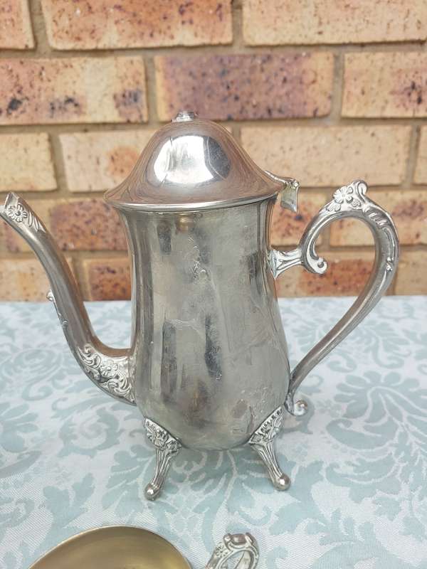 A VINTAGE SILVERPLATE TEAPOT SET WITH A LID HANDLE MISSING SOLD AS IS