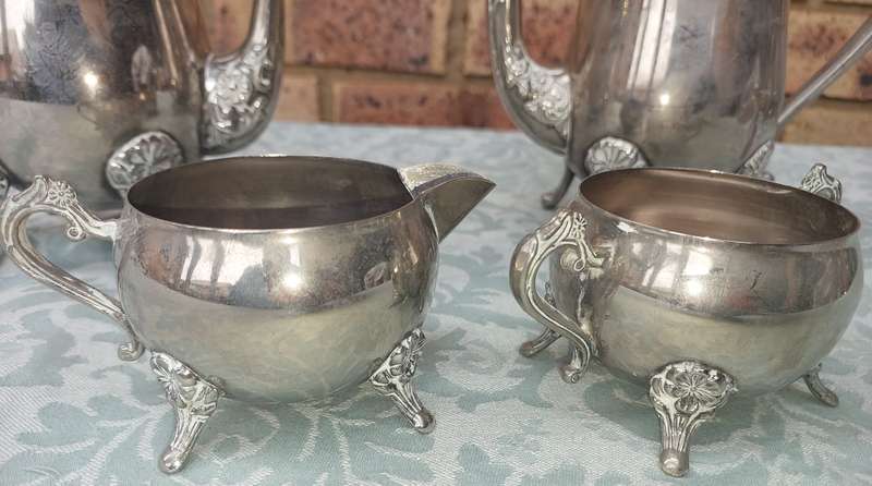 A VINTAGE SILVERPLATE TEAPOT SET WITH A LID HANDLE MISSING SOLD AS IS