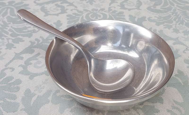 AN ALLOY ROUND SERVING BOWL WITH A LADEL SOLD AS IS