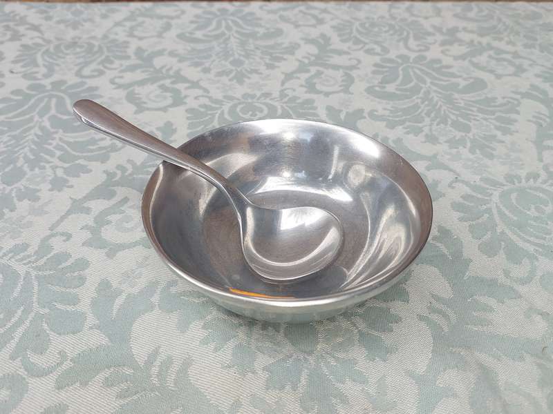 AN ALLOY ROUND SERVING BOWL WITH A LADEL SOLD AS IS