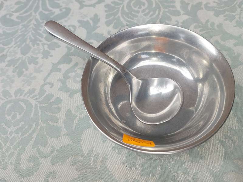 AN ALLOY ROUND SERVING BOWL WITH A LADEL SOLD AS IS
