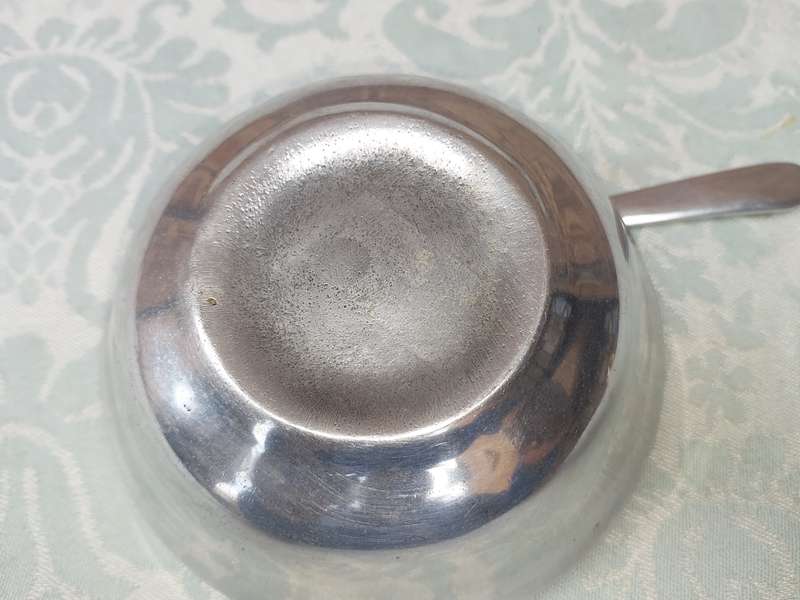 AN ALLOY ROUND SERVING BOWL WITH A LADEL SOLD AS IS