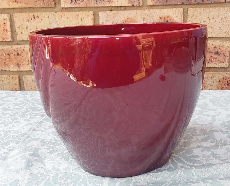 AN ART DECOR BURGUNDY COLOURED POT PLANT HOLDER SOLD AS IS
