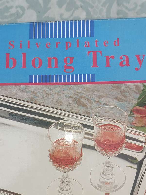A SILVER PLATED OBLONG SERVING TRAY SOLD AS IS