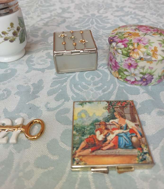 A VINTAGE COLLECTION OF TRINKETS , POCKET MIRRORS AND FIGURINES SOLD AS IS