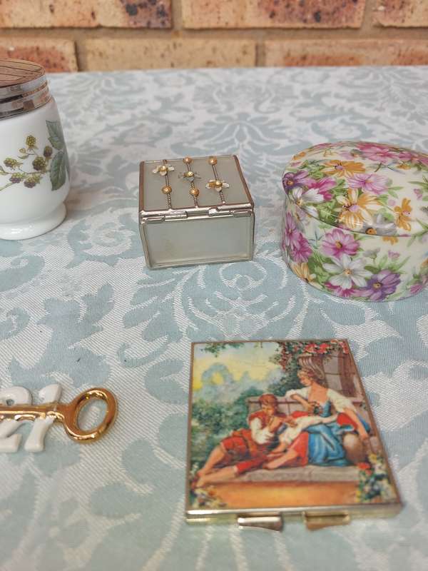 A VINTAGE COLLECTION OF TRINKETS , POCKET MIRRORS AND FIGURINES SOLD AS IS