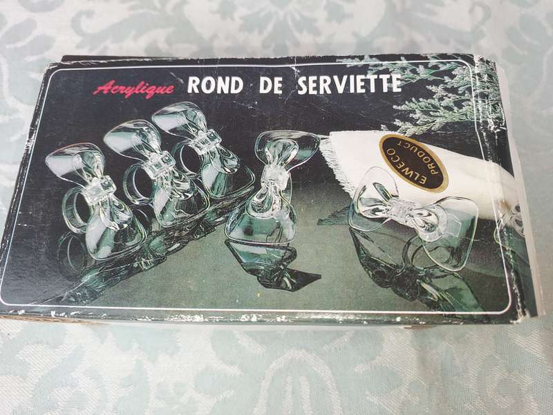 AN ACRYLIQUE SET OF NAPKIN RINGS SOLD AS IS