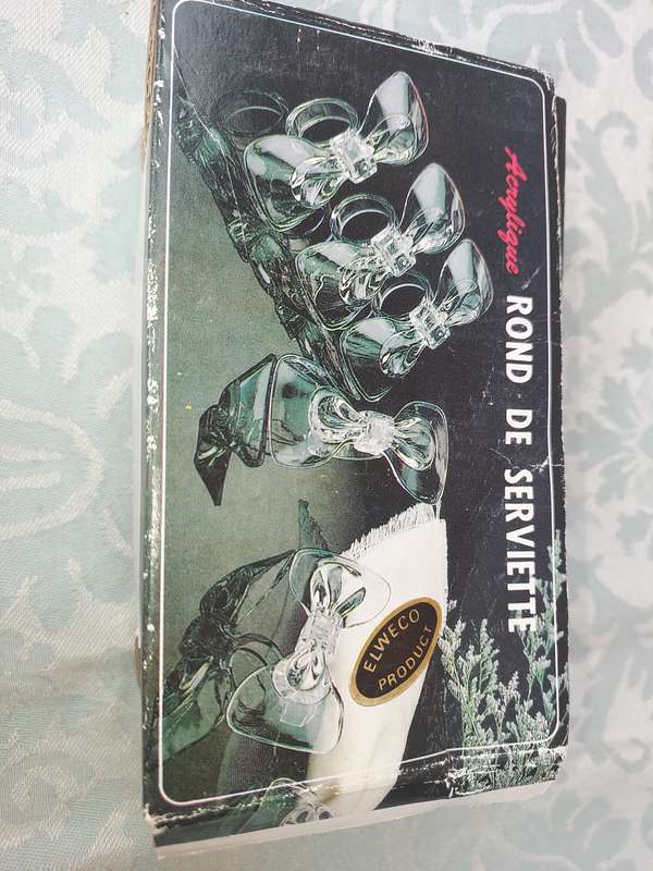 AN ACRYLIQUE SET OF NAPKIN RINGS SOLD AS IS