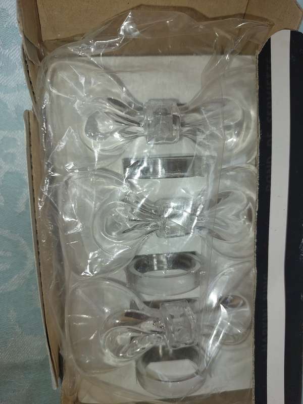 AN ACRYLIQUE SET OF NAPKIN RINGS SOLD AS IS
