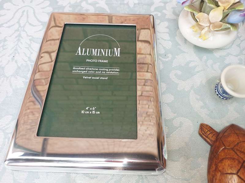 A COLLECTION OF FIGURINES AND A SILVER PLATED PHOTO FRAME SOLD AS IS