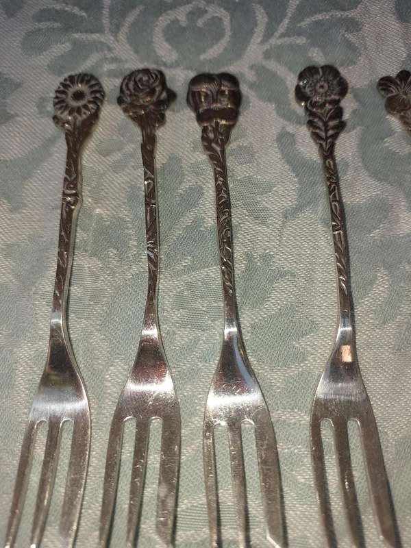 A VINTAGE COLLECTION OF 9 DESERT CUTLERY WITH FLORAL NAMES SOLD AS IS